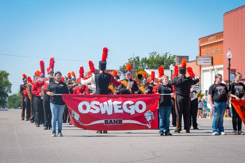 The Oswego marching band lines up behind its red banner.