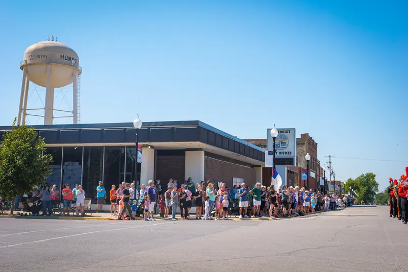 Crowds line the downtown street beneath Humboldt's water tower, waiting for the parade.